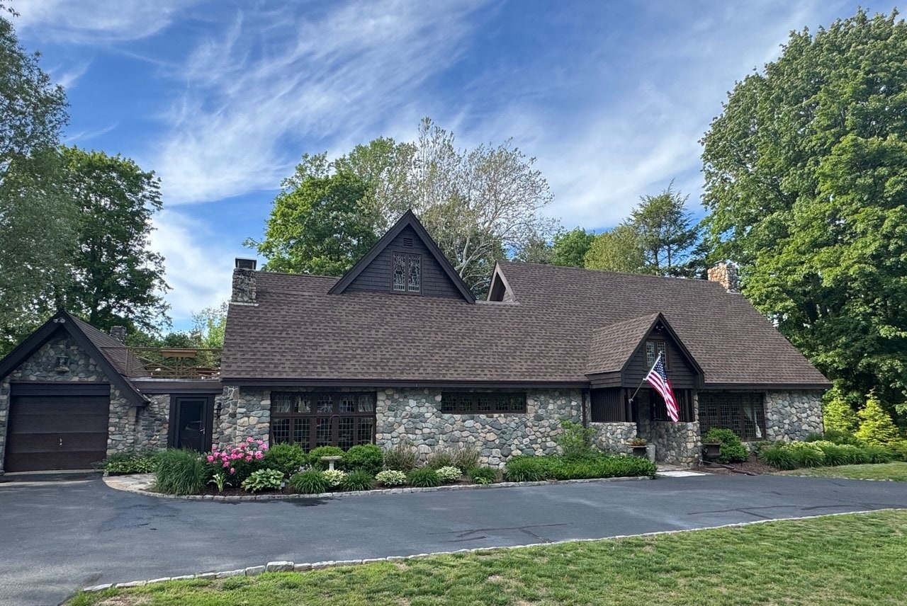 Wide front view of the stone home and attached garage